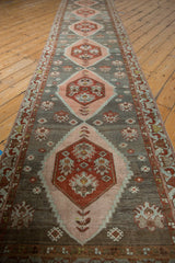 Distressed vintage Malayer runner showing blush and wine geometric medallions with serrated edges and patterned border.