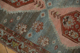 Distressed Malayer rug with abrash, serrated geometric motifs, and a red and blue border.