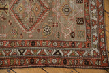 Distressed Northwest Persian runner corner, showcasing geometric border bands in madder red and ivory tones.