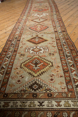 Distressed texture with geometric border patterns in brown, ivory, and brick red.