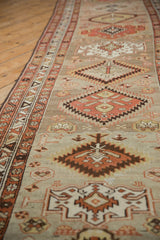 Distressed Northwest Persian runner's serrated geometric medallions and border, with muted madder red and silver tones.
