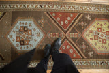 Decorative distressed texture of a Northwest Persian runner with geometric powder blue and terracotta medallions.