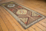 Distressed Northwest Persian runner showing geometric medallion in pale saffron yellow and powder blue.