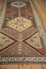 Northwest Persian runner's geometric medallion, stylized florals, saffron, terra cotta, chestnut, even wear.