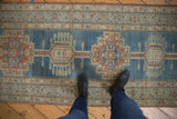 Distressed vintage Serab runner with denim blue ground and terra cotta geometric medallions.