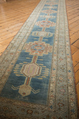 Distressed Serab runner's alternating geometric-floral medallions, abrashed blue ground, and vine borders.