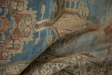 Folded vintage Serab runner showing distressed denim blue and terra cotta geometric patterns with beige accents.