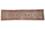 Vintage Karaja runner with a central column of madder red geometric medallions over a distressed beige field.