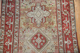Geometric vase medallion and stylized animal figures on the distressed field of a vintage Karaja rug runner.