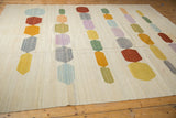 Hand woven Afghani Kilim rug texture, with abstract pebble design elements and varied colors.