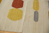 Afghani Kilim abstract flatweave showing pebble shapes in saffron, lilac, and ivory.