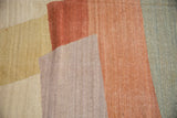 Abstract color blocks with abrashes on Afghani Kilim carpet in mixed neutral and earthy tones.