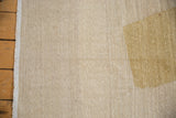 Hand woven Afghani Kilim close-up: abstract gold shape, ivory texture, visible abrashes, side selvage.