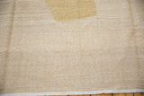 Hand woven Afghani Kilim close-up: abstract ivory and tan flat weave, heavy abrashes, secured edge.