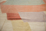 Detail of hand-woven Afghani Kilim with abstract shapes, heavy abrashes in brick red, lavender, and ivory.
