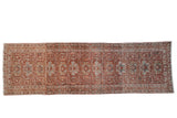 Vintage Karaja Persian runner with a distressed red field, allover palmettes, and interconnecting vinery.