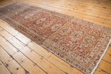 Vintage Karaja runner at an angle, displaying its distressed allover pattern in warm brick red.