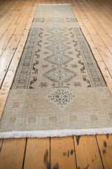 Fringe and worn texture of a distressed Serab runner with faded beige geometric motifs.