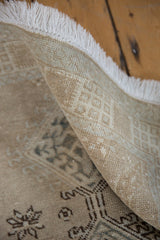 Distressed vintage Serab rug runner showing worn beige pile, subtle patterns, and white fringe.