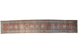 Vintage Distressed Heriz runner, geometric medallions and pinwheel field in brick red, beige, blue.
