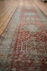 Distressed Heriz runner with pale brick red, blush, beige geometric patterns and visible foundation wear.