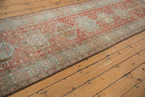 Distressed vintage Heriz runner with faded geometric medallions and worn pile.