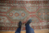 Standing view of a distressed Heriz runner's geometric pattern and time-softened texture.