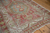 Distressed texture of a vintage Heriz runner in dusty cherry red, powder blue, and ivory.