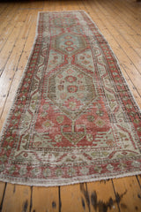 Angled perspective of a vintage Heriz runner, showing the full length and distressed medallion design.