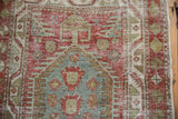 Detailed texture of a distressed Heriz runner showing visible knot heads and foundation.