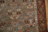 Hamadan runner detail: dusty blue, blush, paneled lattice, and a meandering vine border with wear.
