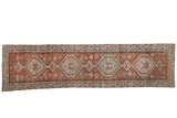 Distressed Northwest Persian rug runner, dusty brick red field with faded blue diamond medallions.