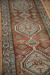Distressed Northwest Persian runner close-up of dusty red field, serrated medallion, and intricate border.