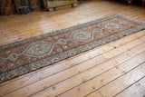 Distressed Northwest Persian runner, brick red field, pale blue medallions, flora and fauna designs.