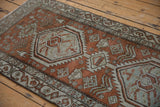 Distressed Northwest Persian runner: dusty brick red field, oxidized silver serrated medallions, worn pile.