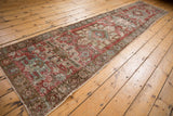 Distressed Persian Heriz runner with faded cherry red and powder blue geometric patterns.