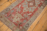 Intact side selvage and textured floral border of a distressed vintage Heriz runner.