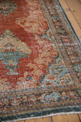 Distressed vintage Mahal runner with brick red ornamental field and patterned border.