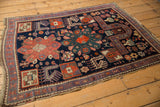 Navy blue vintage Caucasian rug corner with squared medallion and geometric designs.