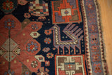 Purple finned animal motif and original selvage on vintage Caucasian rug.