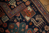 Detail of hand-knotted Caucasian rug shows a beige finned animal and purple, mallard green motifs.