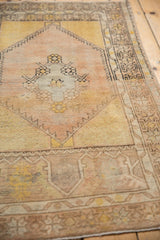 Distressed Vintage Oushak rug showing pale pink, saffron yellow, and wear to knot heads.