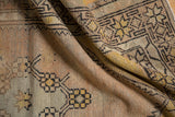 Distressed hand-knotted Oushak rug, showing worn knot heads and soft saffron yellow, pale pink hues.