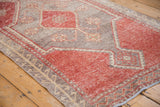 Distressed vintage Oushak runner with pale cherry red guls and plant border.