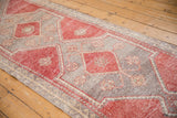Distressed Oushak runner showing pale cherry red guls, oxidized silver field, and germinating plant border.