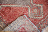 Distressed cherry red pile of the vintage Oushak runner, revealing its hand-knotted foundation.