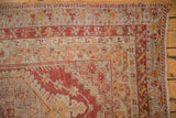 Distressed Anatolian rug short pile, showcasing madder red, pale raspberry, and silver border motifs.