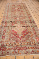 Anatolian runner's distressed pile, madder red and silver tones around a medallion.