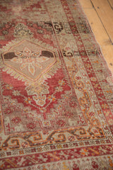 Distressed Anatolian rug border with scrolling arabesque motifs in madder red and silver.