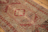Distressed texture and madder red geometric patterns on an Anatolian rug runner end.